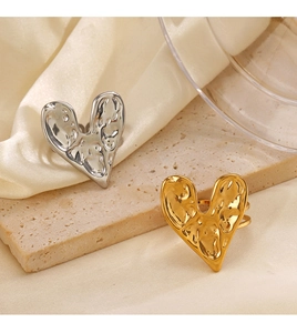 Detailed view of adjustable heart rings with textured liquid metal finish in gold and silver