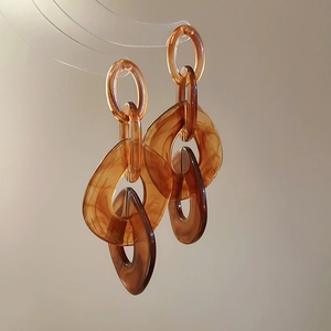 Brown resin chain drop earrings with silver needle studs in a minimalist aesthetic