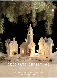 Glow Christmas village scene with snow-covered wooden houses and warm LED lighting detail