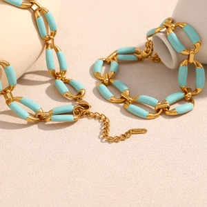 Macro detail of 18K gold-plated chain link necklace with light blue enamel and K18 stamp