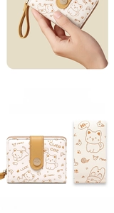 Detail of compact zip wallet showing cute cat pattern and yellow wrist strap design