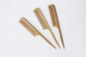 Macro view of three natural wood fine-tooth tail combs for hair styling and parting
