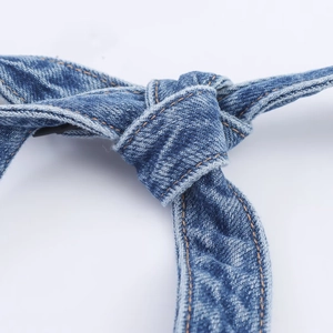 Detail of dark blue denim dress with halter neck tie and orange contrast stitching