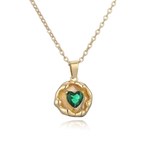 Detailed macro view of an irregular gold pendant with a green heart-shaped gemstone