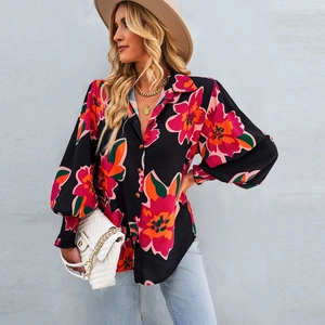 Dettaglio della camicia a fiori con maniche a lanterna e bottoni indossata da modella