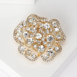 Macro shot of gold rose brooch with sparkling diamonds and hollow metal craftsmanship
