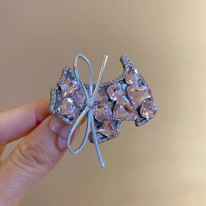 Macro view of pink crystal terrier dog hair clip with sparkling silver bow detail