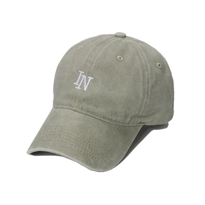 Detail of sage green cotton baseball cap featuring white IN letter embroidery on front