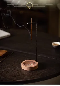 Detail of hanging incense burner with wooden base and black metal stand for meditation