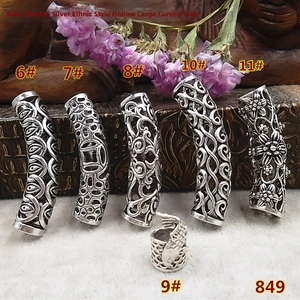 Detail of vintage silver hollow curved tube beads with ethnic cloud and floral patterns