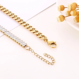 Detail of 18K gold-plated Cuban link chain and zircon-studded necklace on a floral background