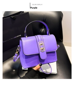 Detail of purple PU leather crossbody bag with cylindrical metal buckle on leather seat