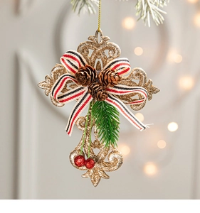 Detail of golden glitter cross ornament with pine cones, red berries and festive bow