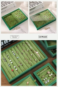 Detail of dark green velvet jewelry tray with ring slots and necklace display compartments