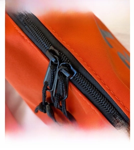 Détail du sac en nylon orange avec fermeture éclair bidirectionnelle et tirette tissée