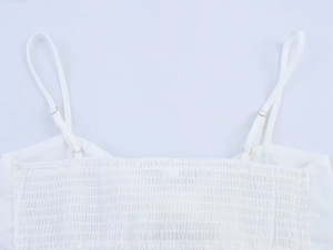Detailansicht des weißen Camisole-Tops mit gerafftem Oberteil und verstellbaren Trägern