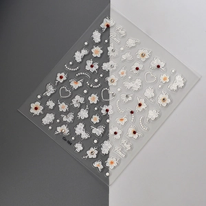 Detail view of 3D embossed white flower nail stickers with sparkling crystal accents