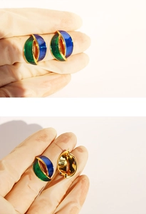 Detail showing blue and green enamel studs with golden metal edges and back pin details