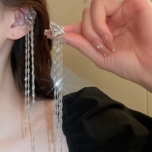 Détail d'un ear cuff papillon argenté avec franges en zircon scintillant et pompons