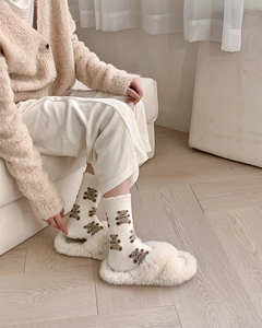 Cozy cream fuzzy socks with brown bear pattern shown with matching plush slippers
