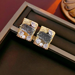 Gold plated rectangular earrings with crystal zircons and pearls on brown velvet tray