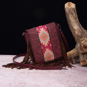 Detail of bohemian fringe crossbody bag with embossed leather and ethnic fabric pattern