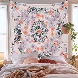 Detail of lavender and orange floral mandala tapestry hanging on a bedroom wall