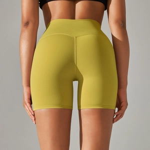 Macro shot of high-waist yoga shorts in mustard yellow with Y-shaped back seam details