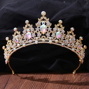 Detailed close-up of Baroque gold crown with sparkling AB rhinestones on black silk