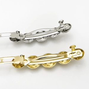 Detail view of gold and silver metallic spring hair clips with textured bead design