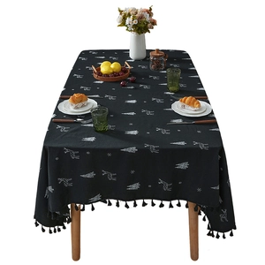 Black Christmas tablecloth with white deer embroidery and elegant fringe tassels on a table