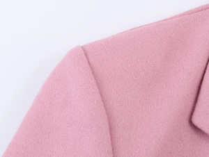 Detail of pink wool blazer shoulder showing high-quality stitching and fabric texture
