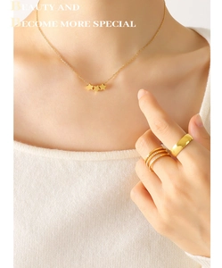 Détail du collier étoile plaqué or 18k et des bagues empilables sur un mannequin