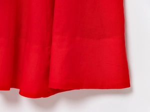 Detail of red cotton midi dress showing high-quality double-stitched hemline craftsmanship