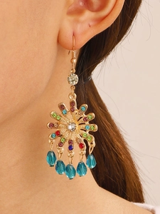 Detail of bohemian sunburst earrings featuring colorful rhinestones and blue teardrop beads