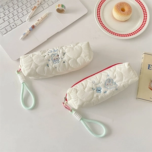 Close-up of quilted heart patterns and cute rabbit embroidery on stationery bags