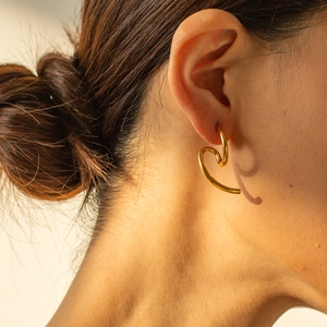 Elegant 18k gold plated stainless steel heart earrings shown on a model side view