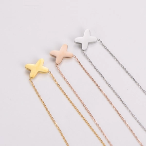 Three minimalist layered cross necklaces in gold, rose gold and silver finishes