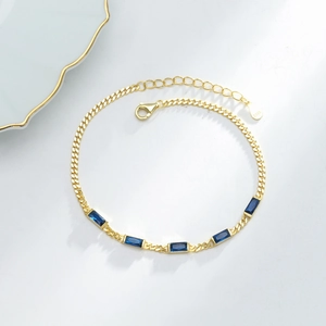 Detail of S925 silver gold bracelet featuring five rectangular blue zircon gemstones
