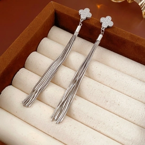 Detail of silver clover earrings with sparkling tassels in a luxury jewelry box