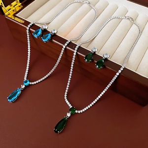 Detail view of pear-cut blue and green zircon jewelry sets in a premium wooden box