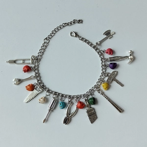 Bracelet à breloques en métal argenté avec divers outils et pendentifs de crânes colorés