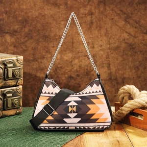 Detail of bohemian geometric print handbag featuring silver chain and adjustable wide strap