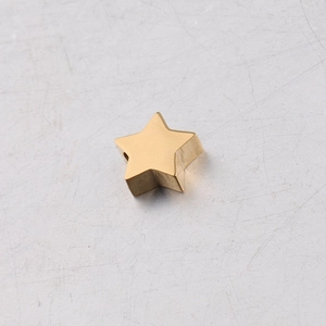 Macro shot of a polished gold star-shaped stainless steel bead for DIY jewelry making