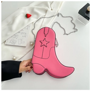 Detail of pink boot-shaped crossbody bag featuring star stitching and silver chain strap