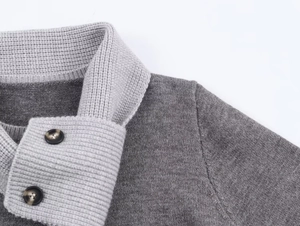 Detail shot of a grey knit sweater collar with ribbed texture and decorative buttons