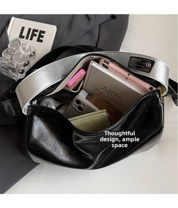 Spacious black Boston bag interior showing storage for tablets and books with silver strap