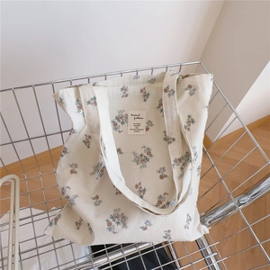 Gros plan d'un sac cabas en coton aux motifs floraux vintage sur un chariot de courses
