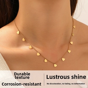 Detailed view of multiple gold heart charms on a delicate stainless steel chain necklace