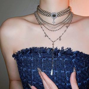 Close-up of elegant multilayer necklace with grey pearls and teardrop crystal pendant